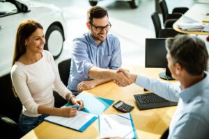 Leasing agent shaking hands with a man at a desk