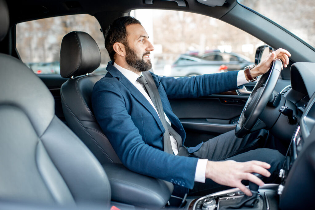 Man in a Suit Sitting in His Newly Leased Car From Autoflex Leasing